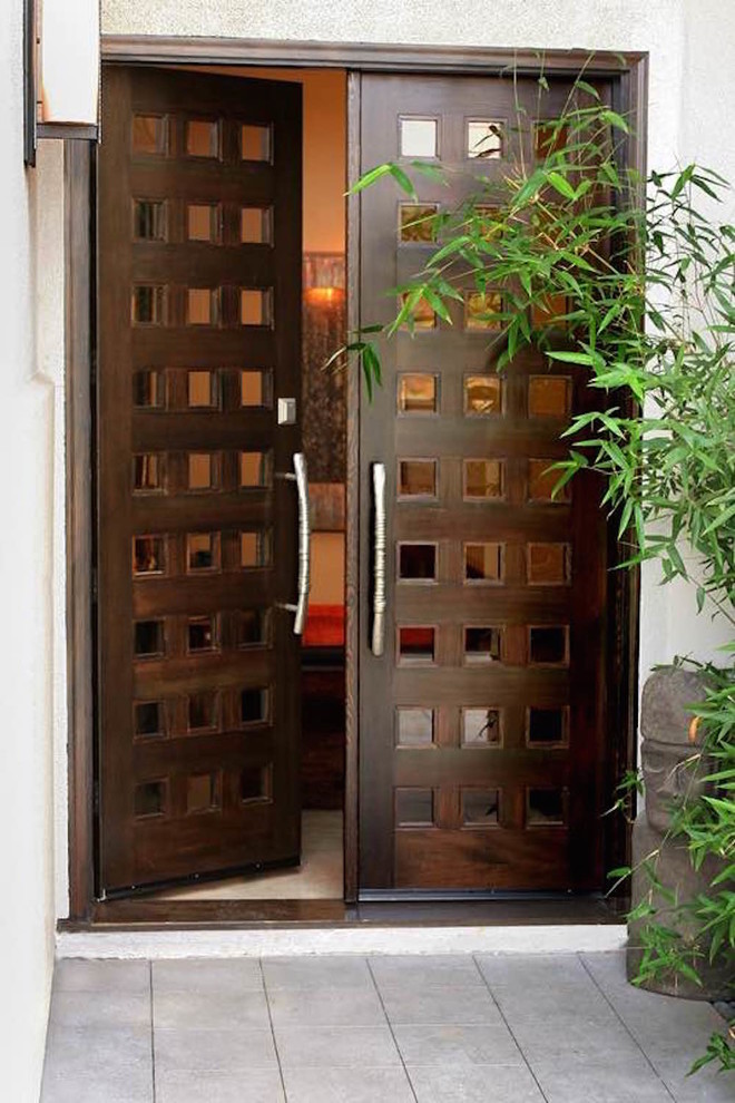 На фото: входная дверь среднего размера в восточном стиле с двустворчатой входной дверью и входной дверью из темного дерева с