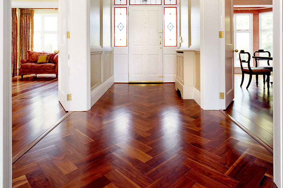 Exemple d'un hall d'entrée chic de taille moyenne avec un mur beige, un sol en bois brun, une porte simple et une porte blanche.