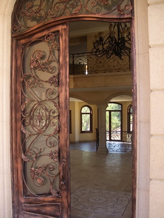 Immagine di una piccola porta d'ingresso mediterranea con pareti beige, una porta a due ante e una porta in metallo