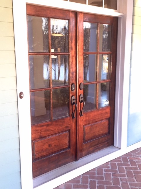 This is an example of a medium sized classic front door in Charlotte with a double front door, a medium wood front door, beige walls, brick flooring and beige floors.