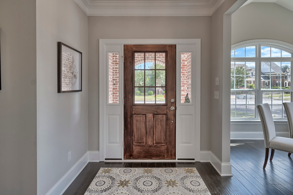 Idée de décoration pour une porte d'entrée tradition de taille moyenne avec un mur beige, parquet foncé, une porte simple et une porte en bois brun.