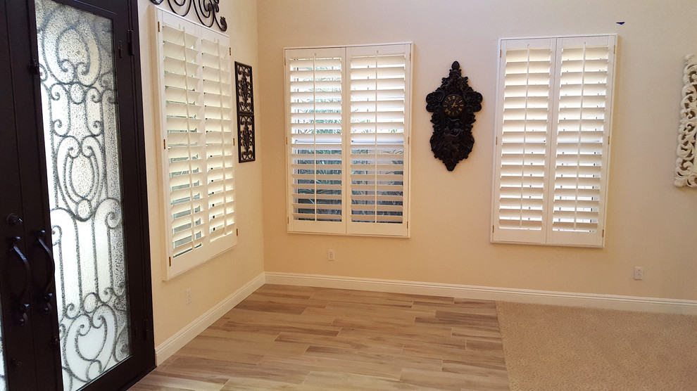 This is an example of a medium sized traditional front door in Las Vegas with beige walls, light hardwood flooring, a double front door and a glass front door.