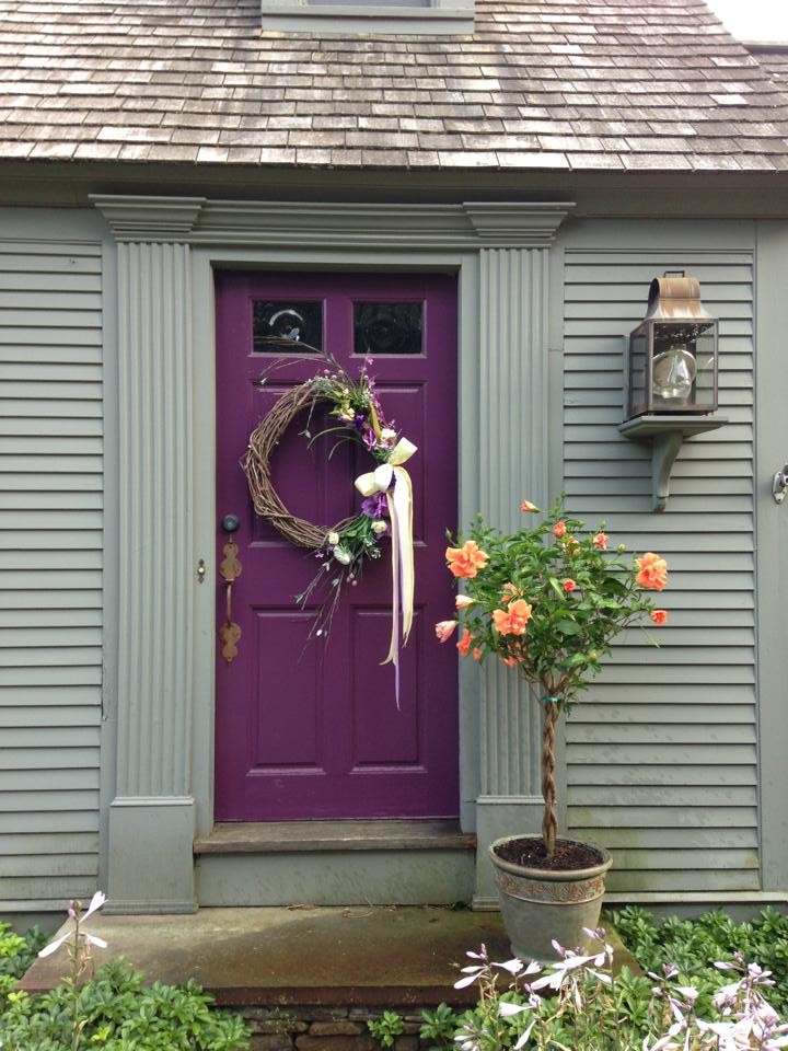 Aménagement d'une entrée craftsman avec un mur vert, sol en béton ciré, une porte simple et une porte violette.