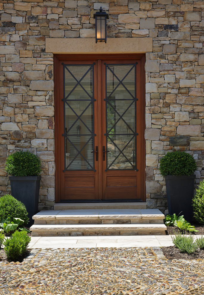 Inspiration pour une porte d'entrée méditerranéenne avec une porte double et une porte en bois brun.