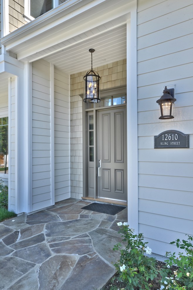 На фото: входная дверь среднего размера в классическом стиле с серыми стенами, одностворчатой входной дверью и серой входной дверью с