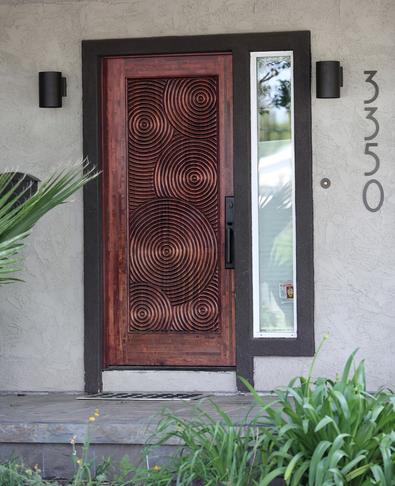 Ejemplo de puerta principal actual de tamaño medio con paredes beige, puerta de madera oscura, suelo de pizarra y puerta simple