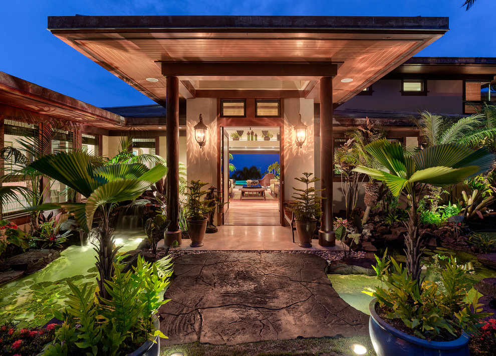 Example of a large island style front door design in Hawaii with a dark wood front door