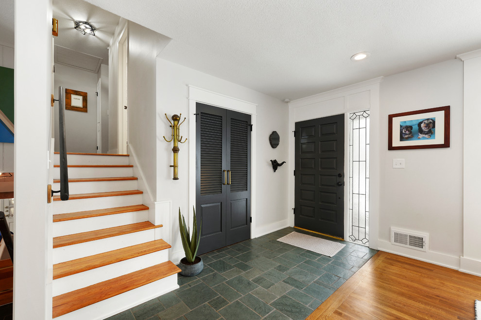 Пример оригинального дизайна: маленькая входная дверь в классическом стиле с белыми стенами, полом из сланца, одностворчатой входной дверью, черной входной дверью и зеленым полом для на участке и в саду