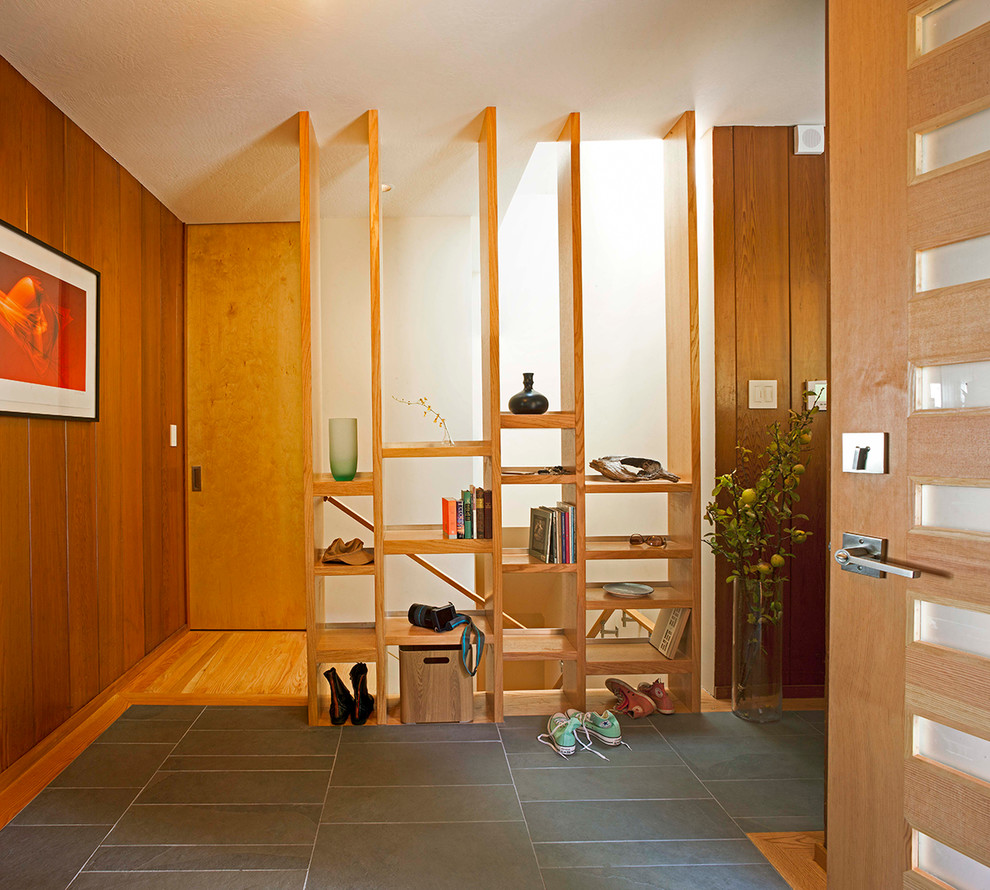 Example of a mid-sized trendy slate floor entryway design in San Francisco with white walls and a light wood front door