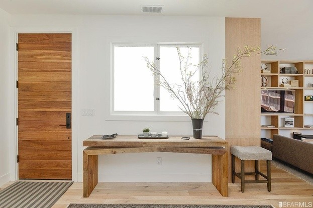 Inspiration for a small contemporary light wood floor entryway remodel in San Francisco with white walls and a medium wood front door
