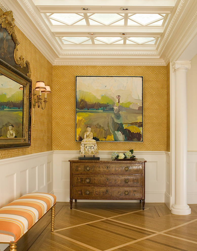 Réalisation d'une grande entrée tradition avec un couloir, un sol en bois brun, un sol marron et un mur beige.