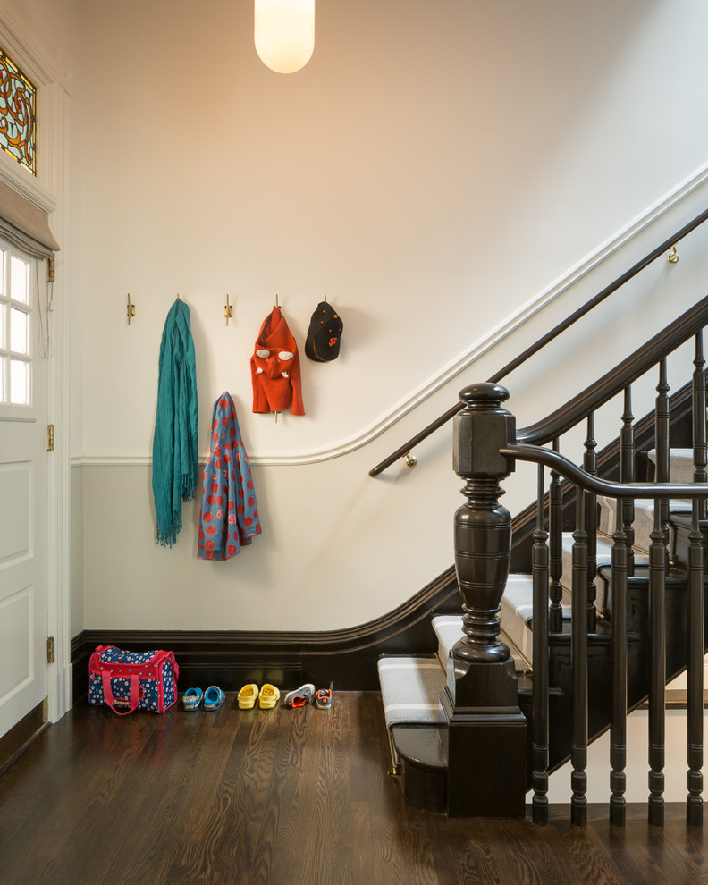 Photo of a victorian foyer in San Francisco with white walls, dark hardwood flooring, a white front door and a dado rail.