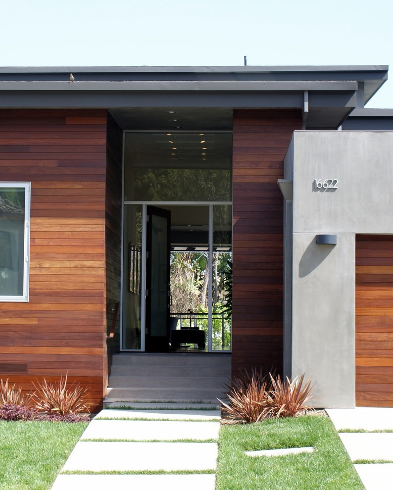 This is an example of a contemporary front door in Los Angeles with a single front door and a glass front door.