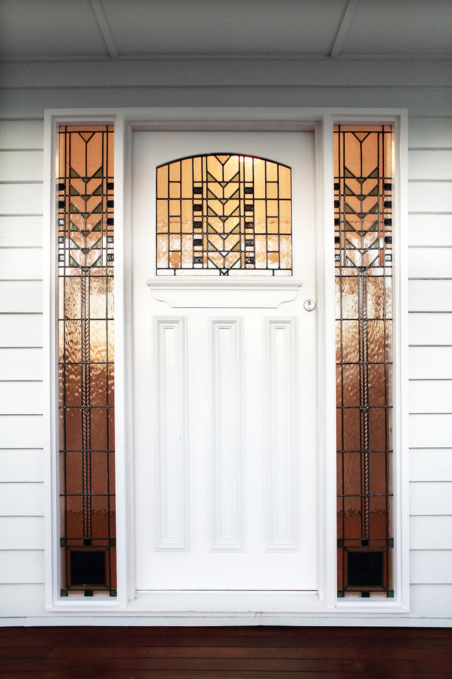 На фото: входная дверь среднего размера в стиле кантри с белыми стенами, деревянным полом, одностворчатой входной дверью, белой входной дверью и коричневым полом