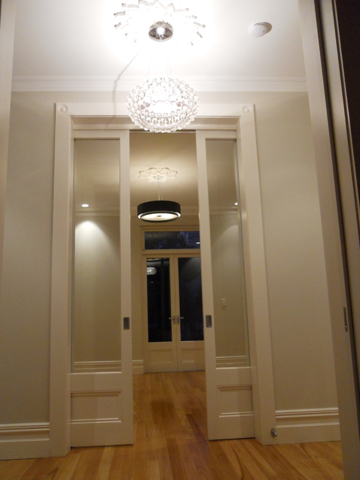 Ispirazione per un ingresso minimal di medie dimensioni con parquet chiaro, una porta a due ante e una porta bianca