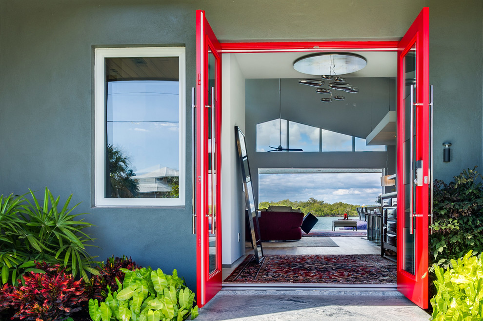 Cette photo montre une grande porte d'entrée tendance avec un mur gris, parquet clair, une porte double et une porte rouge.