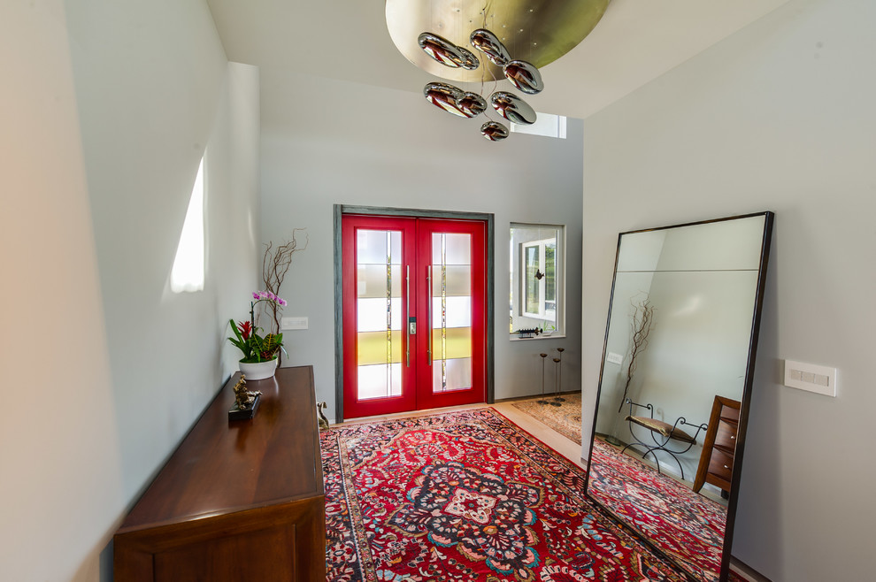 他の地域にある広いコンテンポラリースタイルのおしゃれな玄関ドア (グレーの壁、淡色無垢フローリング、赤いドア) の写真