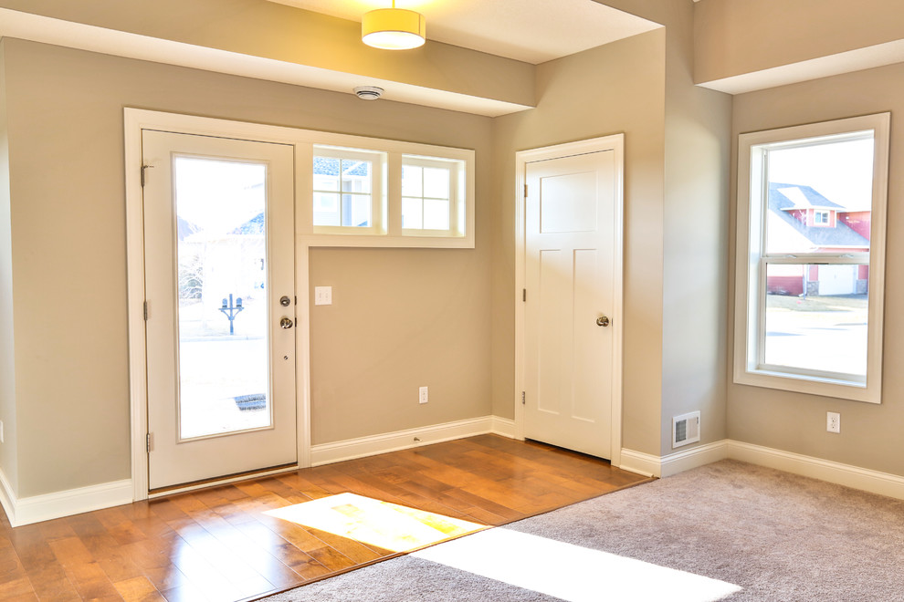Small modern front door in Minneapolis with beige walls, light hardwood flooring, a single front door and a glass front door.