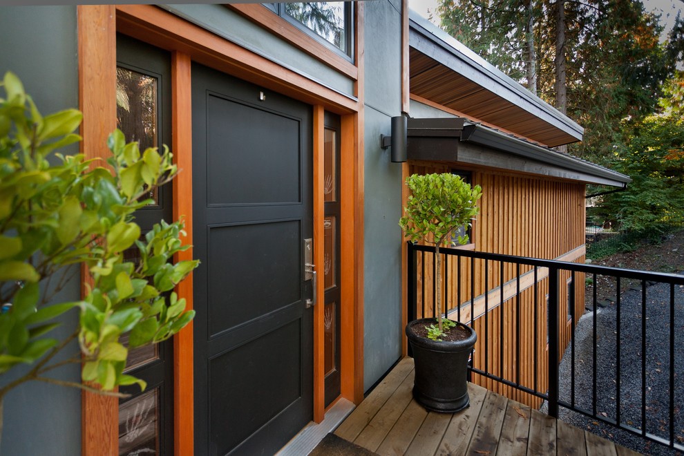 Idée de décoration pour une porte d'entrée design avec un mur gris, une porte simple et une porte noire.