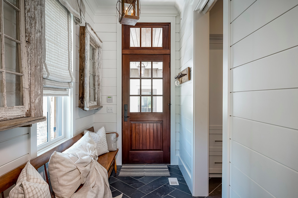 Стильный дизайн: большая узкая прихожая в стиле кантри с белыми стенами, полом из сланца, одностворчатой входной дверью, входной дверью из темного дерева и синим полом - последний тренд