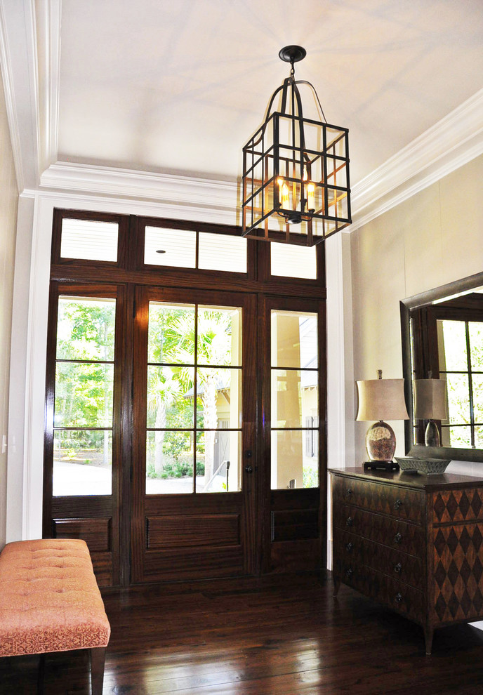 Exemple d'un hall d'entrée chic de taille moyenne avec un mur beige, parquet foncé, une porte simple et une porte en verre.