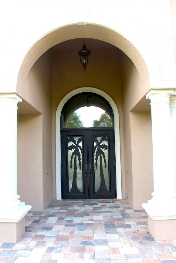 Идея дизайна: большая входная дверь в средиземноморском стиле с двустворчатой входной дверью и металлической входной дверью