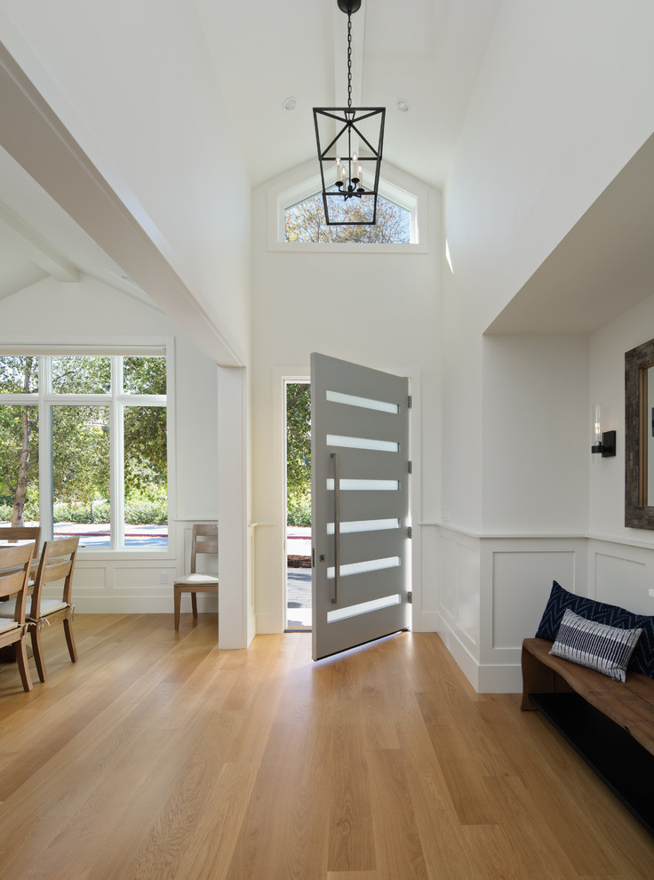 This is an example of a large country foyer in San Francisco with white walls, medium hardwood flooring, a single front door, a grey front door and brown floors.