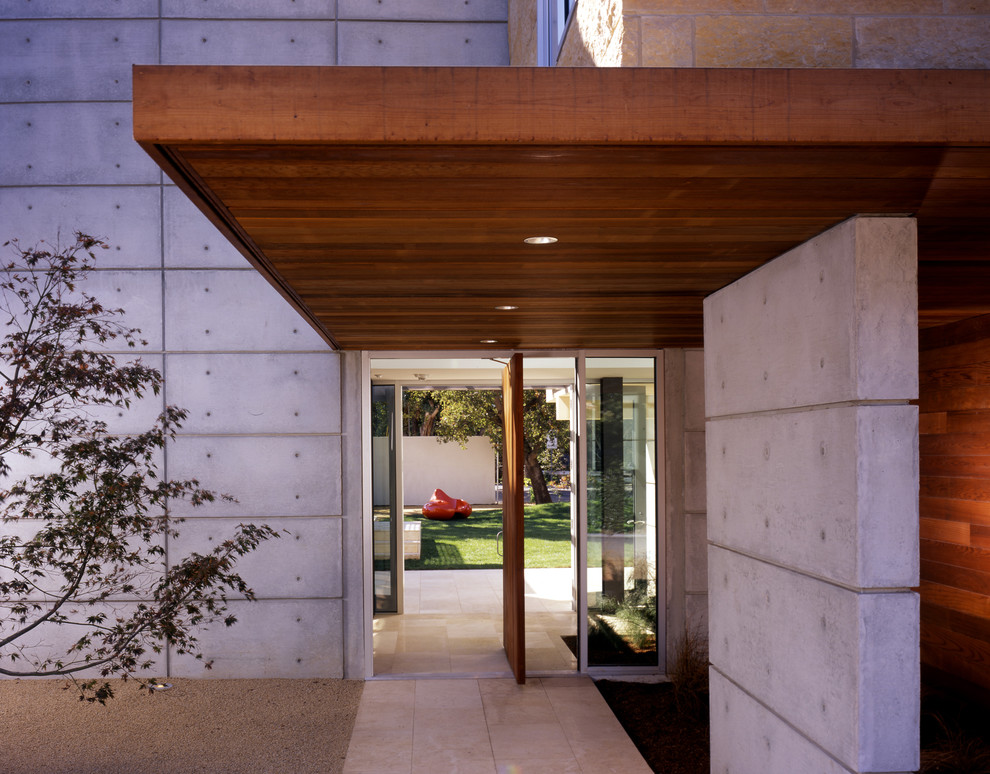 Réalisation d'une grande porte d'entrée minimaliste avec une porte pivot et une porte en bois brun.