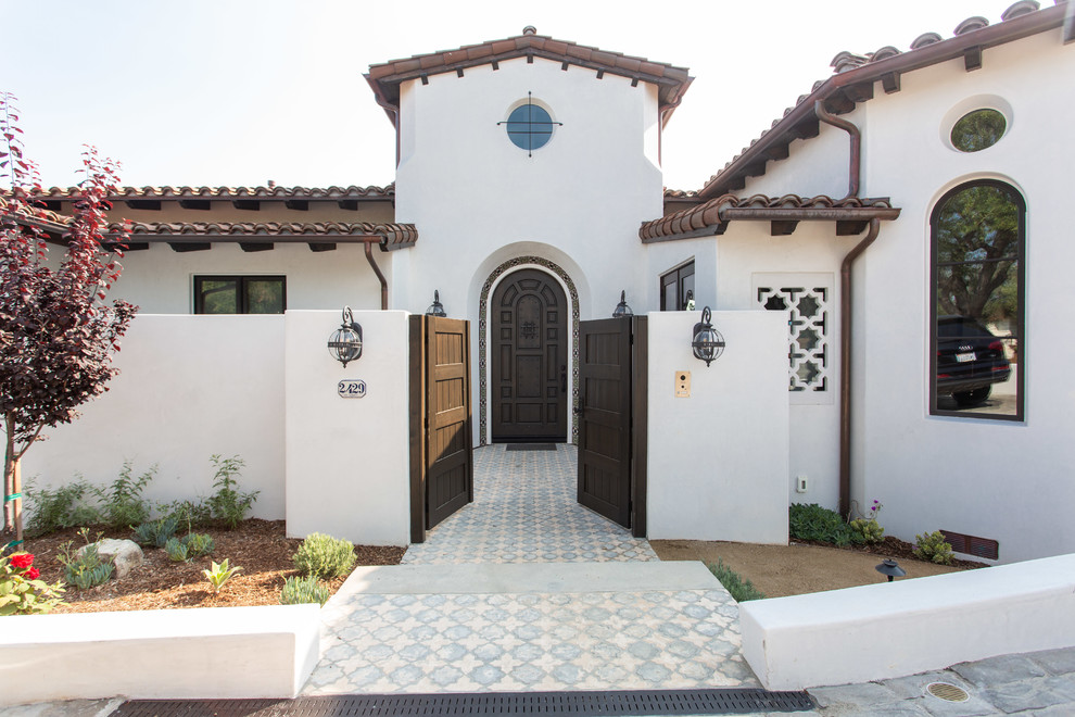 Mediterrane Haustür mit weißer Wandfarbe, Einzeltür, dunkler Holzhaustür und buntem Boden in Los Angeles