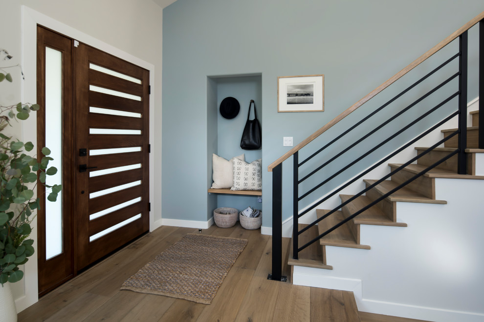 Inspiration for a mid-sized transitional light wood floor entryway remodel in Los Angeles with blue walls and a dark wood front door
