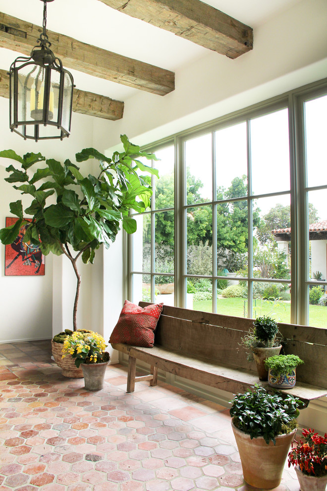 Entryway - mediterranean terra-cotta tile and red floor entryway idea in Los Angeles