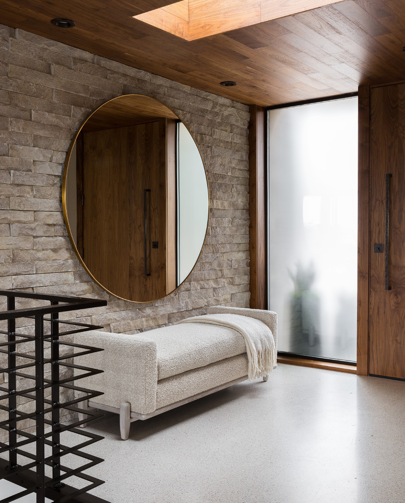 Foto de distribuidor actual con paredes grises, puerta simple, puerta de madera en tonos medios y suelo beige
