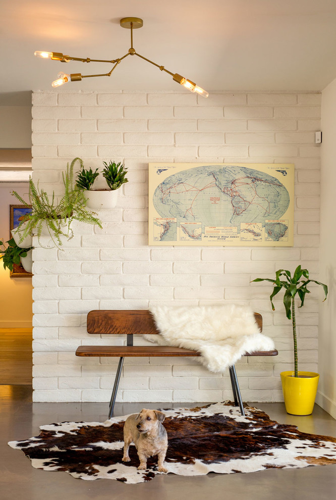 На фото: фойе среднего размера в стиле ретро с белыми стенами, бетонным полом и серым полом