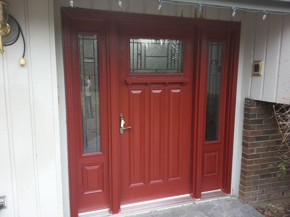 This is an example of a front door in Calgary with white walls, concrete flooring, a single front door and a red front door.
