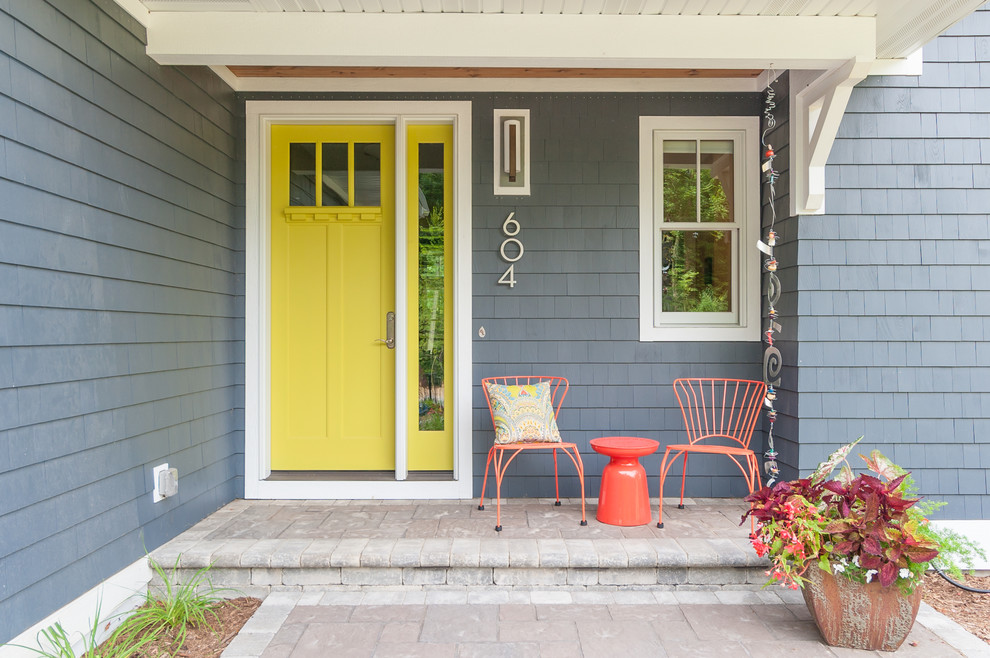 Classic entrance in Grand Rapids with grey walls, a single front door and a yellow front door.