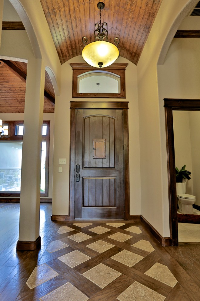 Exemple d'une petite porte d'entrée méditerranéenne avec un mur beige, parquet foncé, une porte simple et une porte en bois foncé.
