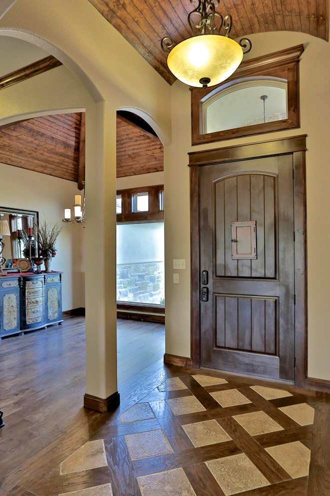 Small tuscan dark wood floor entryway photo in Dallas with beige walls and a dark wood front door