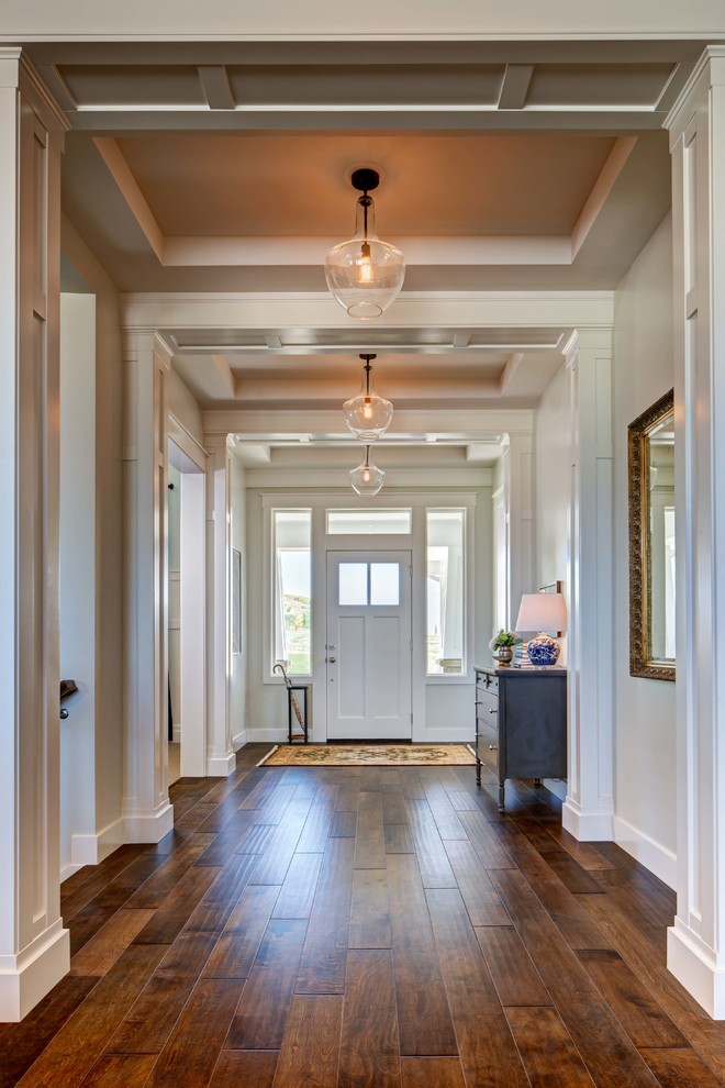 На фото: узкая прихожая: освещение в классическом стиле с белыми стенами, одностворчатой входной дверью и белой входной дверью