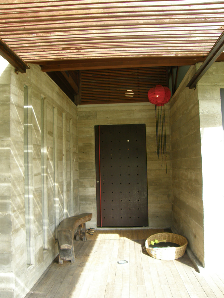 Foto de puerta principal tropical de tamaño medio con paredes grises, suelo de madera en tonos medios, puerta pivotante, puerta metalizada y suelo marrón