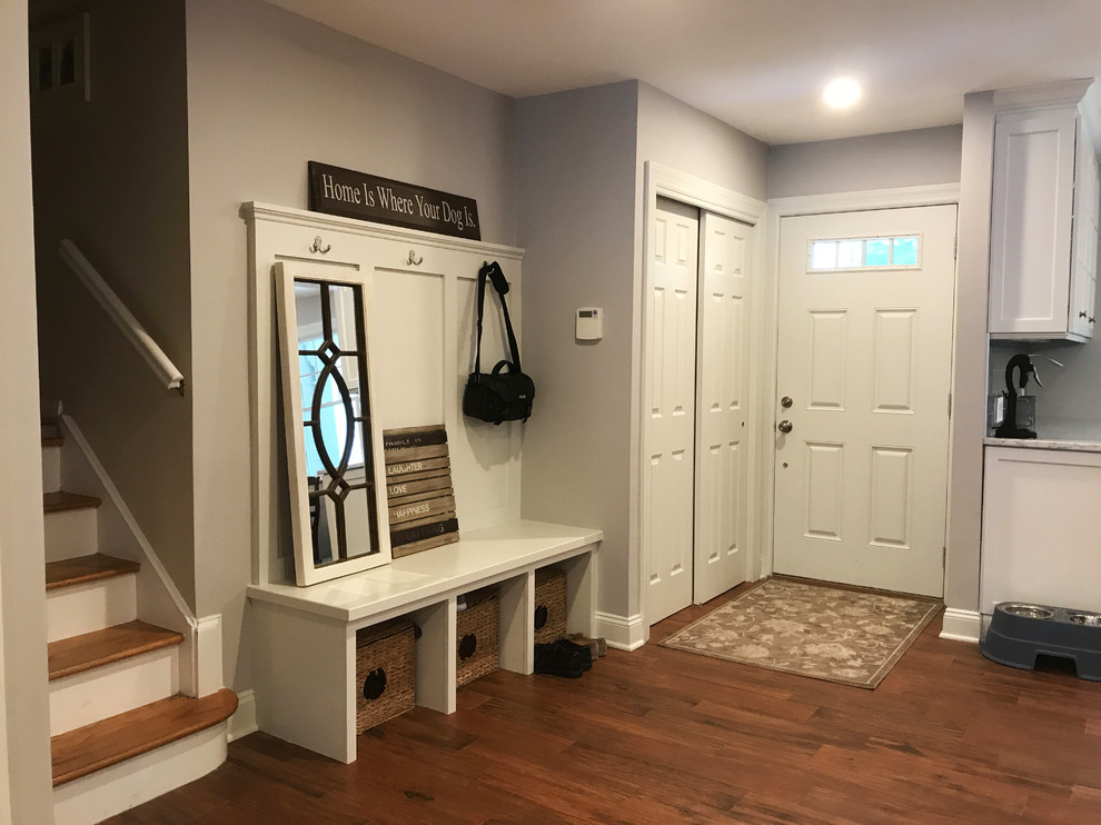 Photo of a medium sized traditional vestibule in New York with grey walls, medium hardwood flooring, a single front door, a white front door and brown floors.