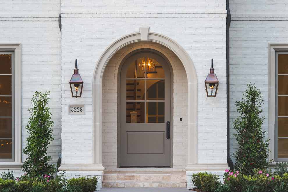 На фото: входная дверь в классическом стиле с одностворчатой входной дверью и серой входной дверью