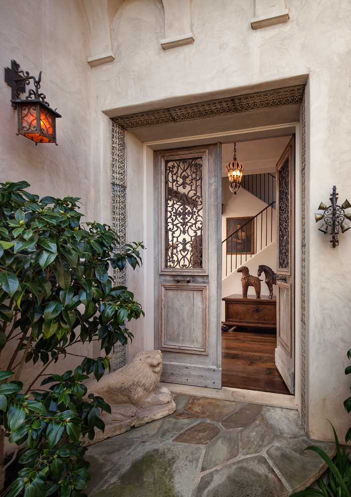 На фото: входная дверь в средиземноморском стиле с двустворчатой входной дверью и входной дверью из светлого дерева с