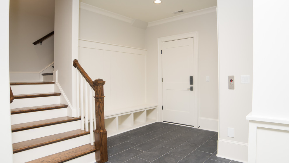 Diseño de vestíbulo posterior de estilo americano de tamaño medio con paredes beige, puerta simple, puerta blanca y suelo gris