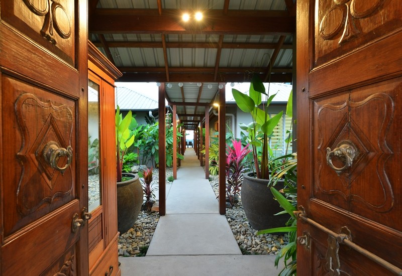 Diseño de puerta principal de estilo zen grande con suelo de cemento, puerta doble y puerta de madera en tonos medios