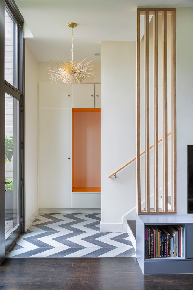 Large scandi boot room in New York with white walls, a glass front door, dark hardwood flooring, a single front door and brown floors.