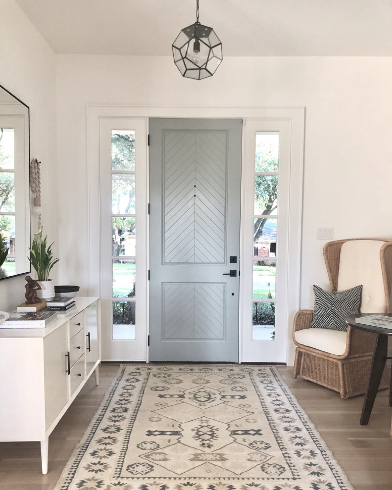 ダラスにあるトランジショナルスタイルのおしゃれな玄関 (白い壁、無垢フローリング、グレーのドア、茶色い床) の写真