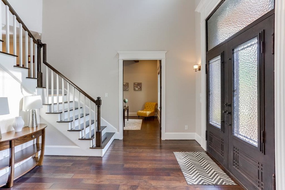 Entryway - mid-sized craftsman medium tone wood floor and multicolored floor entryway idea in Houston with beige walls and a black front door