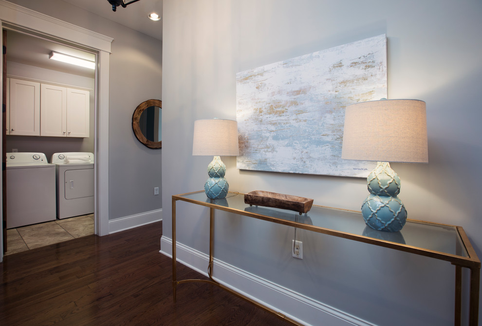 This is an example of a medium sized contemporary hallway with grey walls, medium hardwood flooring and brown floors.
