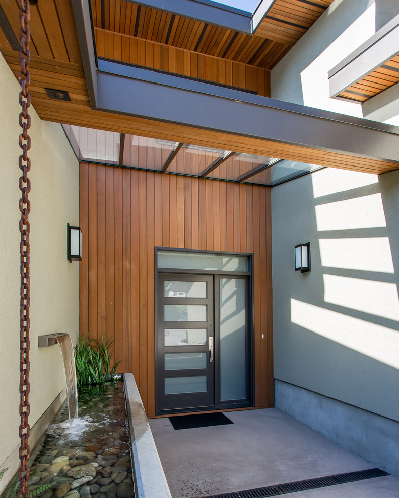 Large modern front door in Vancouver with multi-coloured walls, concrete flooring, a single front door, a glass front door and grey floors.
