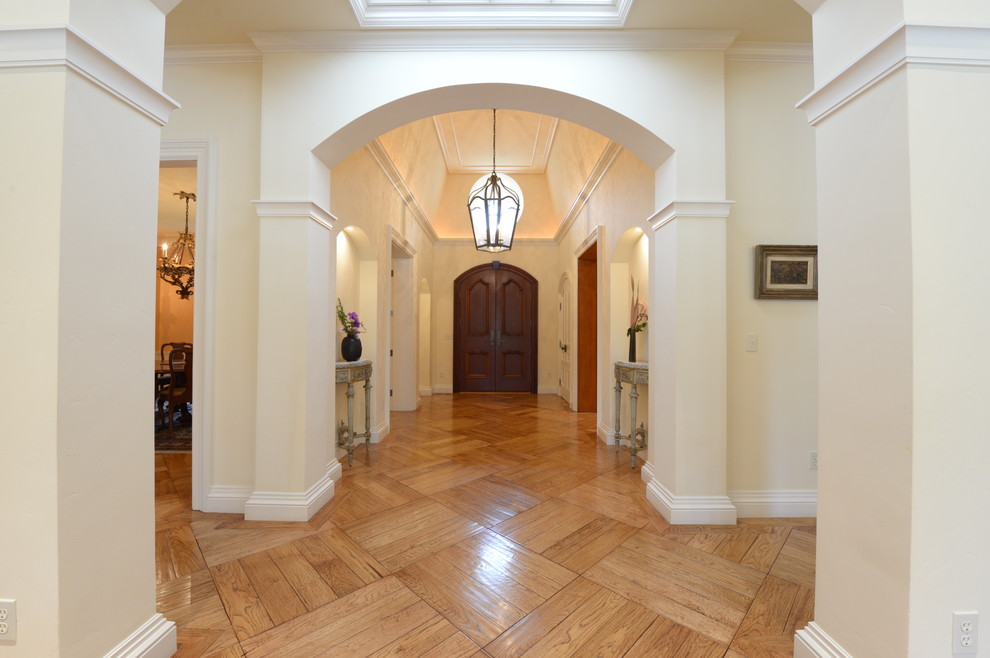 Foto di un grande ingresso classico con pareti beige e pavimento in legno massello medio